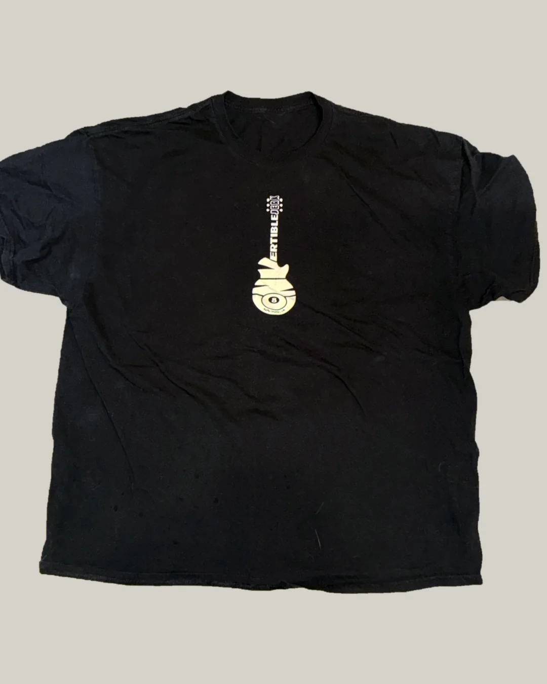 The black band tee laid flat, with the cream guitar logo on the chest