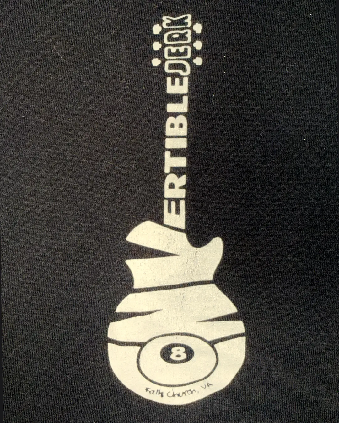 Close-up of the logo on the tee: a cream guitar that spells convertibleJERK, with an 8-ball and Falls Church, VA on its body